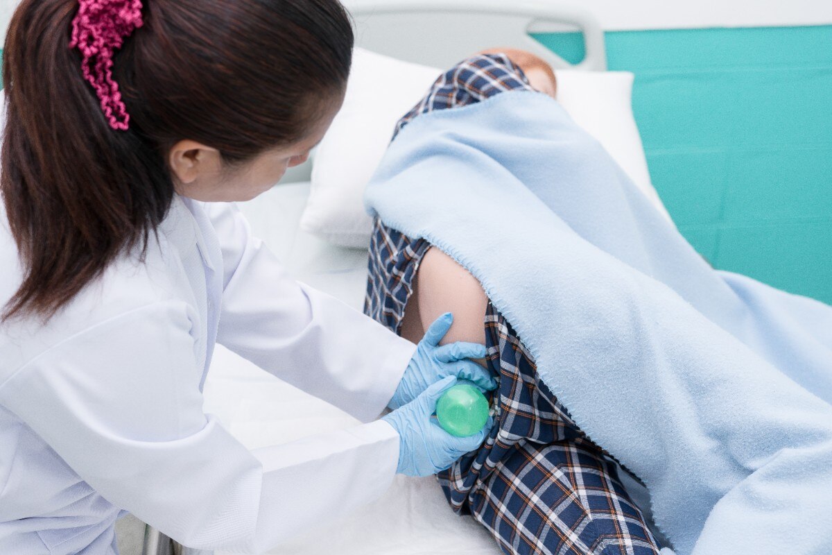 Doctor gives her patient for enema to resolve constipation problem. ; Shutterstock ID 683250976; Business Unit: Jones & Bartlett Learning; Project Name: ATI Fundamentals; ISBN or Project Number: ATI FUND; Element Number: ATIFUND_CH32_UNNSWR50
